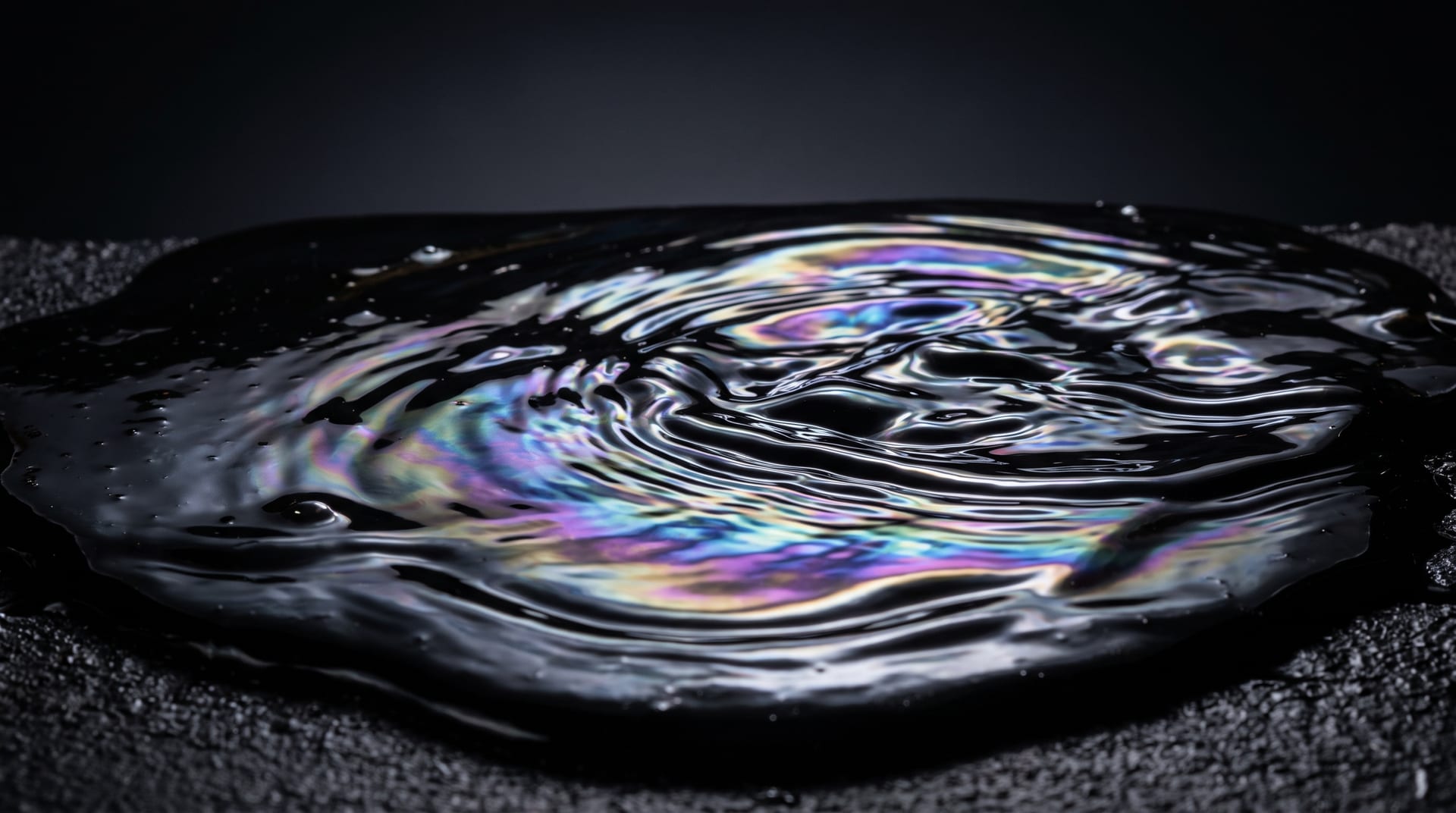 Macro studio photograph of glossy black crude oil rippling